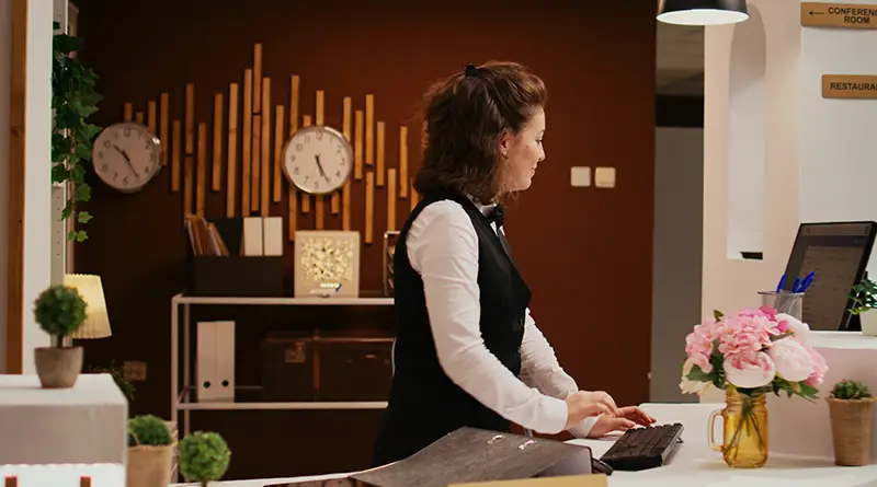 Hotel receptionist greeting regular guest with personalized welcome note